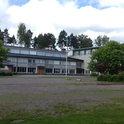 En grå och röd byggnad i Karis som är Karis-Billnäs gymnasium och Karis svenska högstadium.