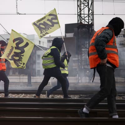 Järnvägsarbetare på ett järnvägsspår demonstrerar mot regeringens pensionsreform i Frankrike.