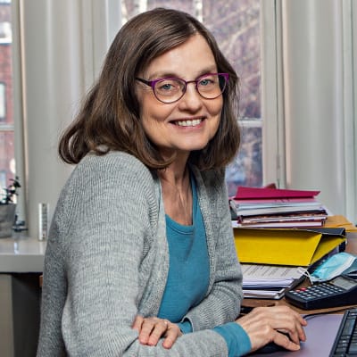 Glasögonprydd kvinna i sitt arbetsrum på Wasa Teater. Marit Berndtson, administrativ chef. 