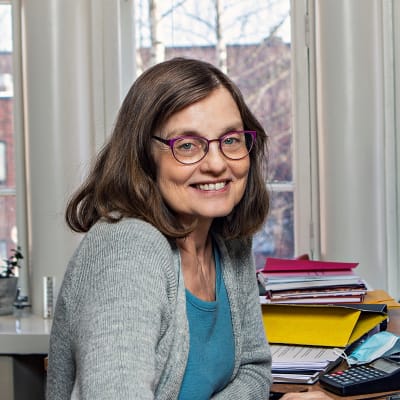 Glasögonprydd kvinna i sitt arbetsrum på Wasa Teater. Marit Berndtson, administrativ chef. 