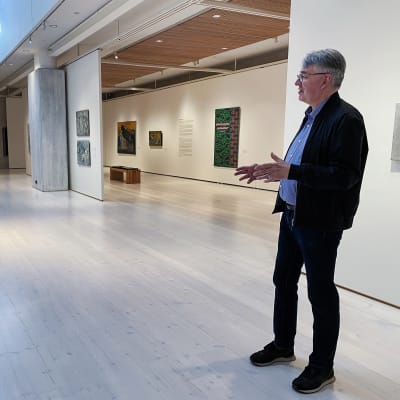 Mies kertoo taidenäyttelystä taidemuseossa.