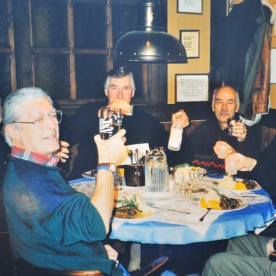 Sex män sitter runt ett dukat bord. 