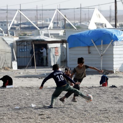 Lapsia pelaamassa jalkapalloa pakolaisleirillä.
