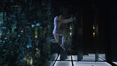Major (Scarlett Johansson) kommer inhoppande genom ett fönster och glassplittret yr.