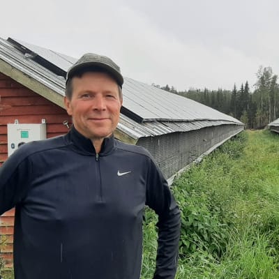 Man framför gamla rävhus.