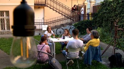 En grupp människor runt ett bord i en trädgård