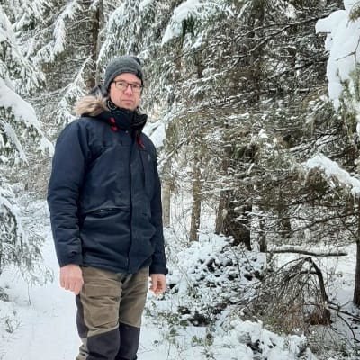 Man i vintrig granskog.