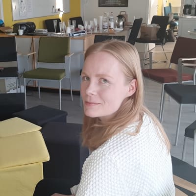 Kuhmon kirjasto- ja kulttuuripäällikkö Hanne Heikkinen istuu Kuhmon kulttuuriolohuoneessa.