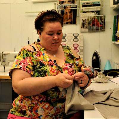 Företagaren Erica Wickman gör ändringsarbeten i sin kombinerade syateljé och klädbutik