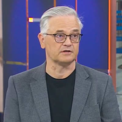 Hannu Kiviranta pratar och tittar åt sidan. 