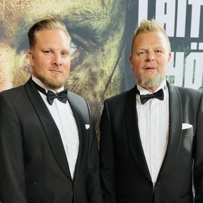 Näyttelijä Severi Saarinen  ja Marko Jantunen seisoo Laitapuolen hyökkääjä elokuvajulisteen edessä.