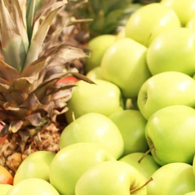 Röda äpplen, ananas och gröna äpplen i närbild.