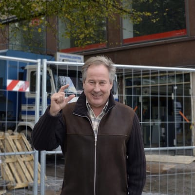 Simo Leporanta tekee tutun tervehdyksen remontissa olevan kiinteistön edustalla, jossa Vaatehuone aikanaan sijaitsi.