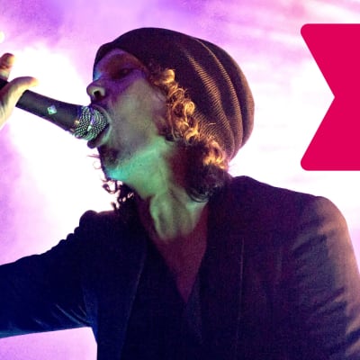 Ville Valo håller en mikrofon i munnen.