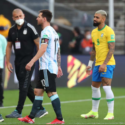 Argentinas tränare Lionel Scaloni och storstjärnan Lionel Messi lämnar planen efter att matchen stoppats.