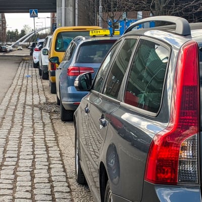 Bilar står parkerade längs en gata.