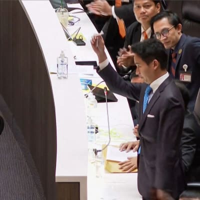 Det thailändska framstegspartiets ledare och premiärministerkandidat Pita Limjaroenrat tar av sig sitt parlamentsmärke