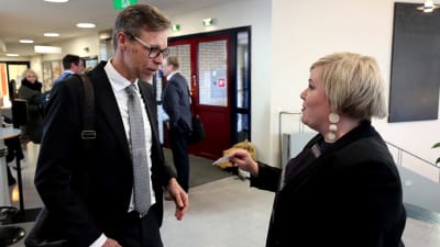 Ministeri Annika Saarikko antaa käyntikorttinsa juuri valitulle Varsinais-Suomen hyvinvointialueen johtajalle Tuomo Martikaiselle