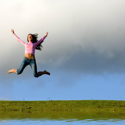 En flicka hoppar högt upp i luften.