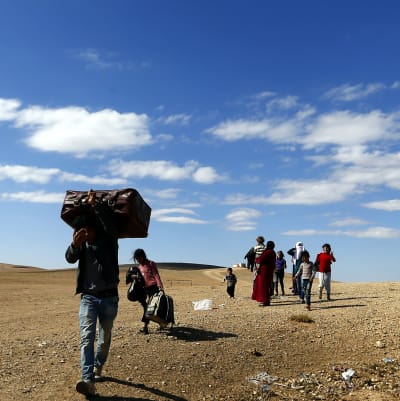 Folk på flykt undan IS överskrider gränsen mot Turkiet.