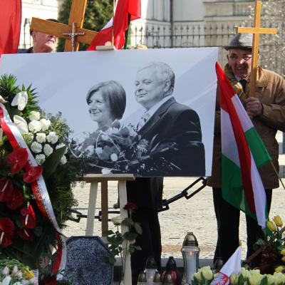 Polens president Lech Kaczyński och hans fru Maria som dog i en flygolycka i Smolensk hedras utanför presidentpalatset i Warszawa.
