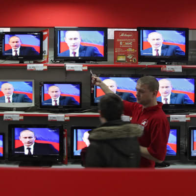 En elektronik affär i Ryssland med TV apparater som visar Vladimir Putin. 