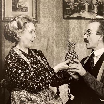 Ett svartvitt foto av en man och en kvinna som håller i en ananas. 
