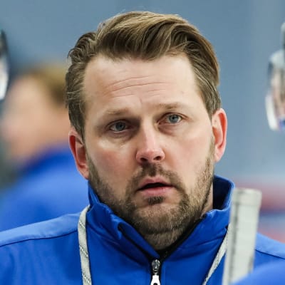 Antti Pennanen tittar allvarligt mellan två spelare.