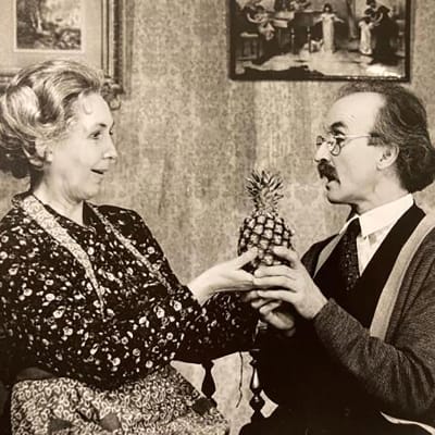 Ett svartvitt foto av en man och en kvinna som håller i en ananas. 
