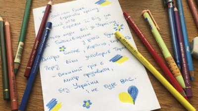 Kuvassa on värikyniä ja ukrainaksi kirjoitettu runo.