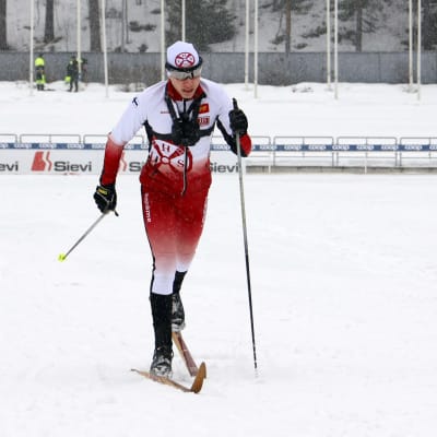 Lahden hiihtoseuran Onni Mäiselin kokeilee vanhoja Järvisen puusuksia Lahden hiihtostadionilla.