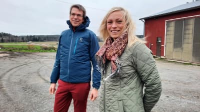 Ida Fredriksson och Tomas Björkroth framför en åker i höstigt, blåsigt väder.