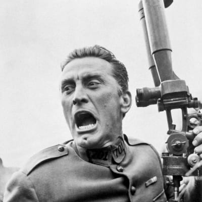 Ensimmäisen maailmansodan ranskalaisupseeri (näyttelijä Kirk Douglas) on kääntänyt katseensa periskoopista ja huutaa suu ammollaan. Kuva elokuvasta Kunnian polut.