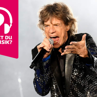 Mick Jagger sjunger i en mikrofon som han håller i handen.