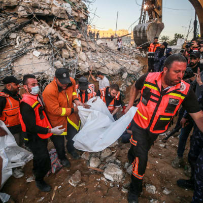 Räddningspersonal i ruinerna efter ett palestinskt hus som bombats i  Beit Lahia, Gaza 13.5.2021