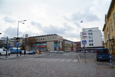 Vy av en korsning mitt i Borgå där bilar kör förbi. I blickfånget ligger ett stort brunt hus som det står Citymarket på.