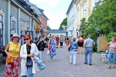 Turister på en gata i Gamla stan i Borgå. Det är sommar och vackert väder.
