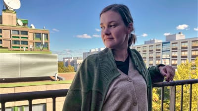Maria Sannström tittar ner från en balkong i östra Böle, 