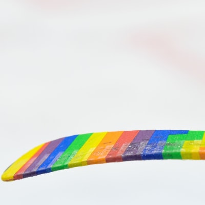 En ishockeyklubba i regnbågsfärger.