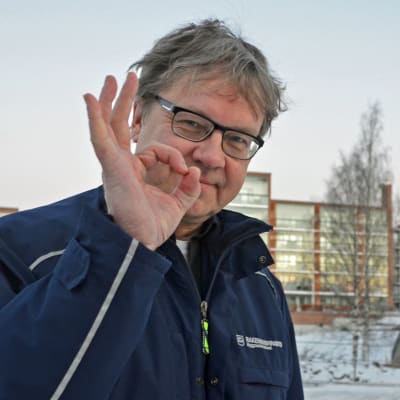 Pekka Sauri poserar med handen höjd i en OK-gest.