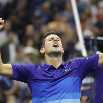 Novak Djokovic sträcker armarna i luften.