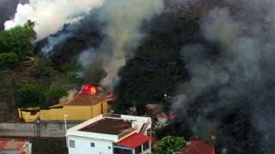 Svart lava närmar sig hus som börjat brinna.