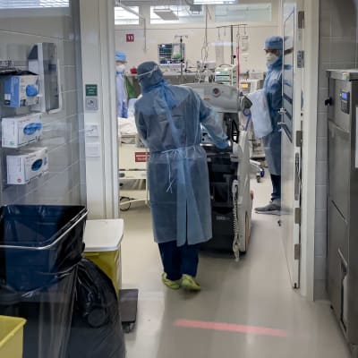 Oulun Yliopistollisen sairaalan korona teho-osastolla sairaalan henkilökunta tuovat röntgenlaitetta teho huoneeseen.
