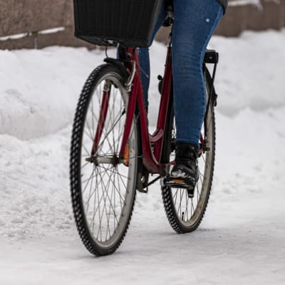 Lähikuva pyörästä jossa pyöräilijä polkee talvisessa Oulussa