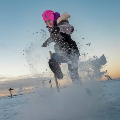 Oululainen Netta Brandt potkaisee lunta kameraa kohti