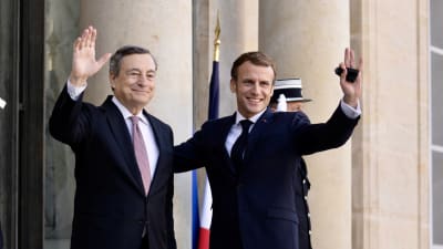 Mario Draghi till vänster och Emmanuel Macron till höger. Bakom Macron skymtar en soldat och den franska flaggan.