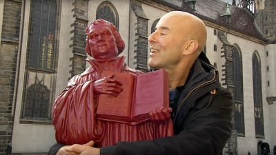 Mark Levengood med en röd Martin Luther-staty i famnen