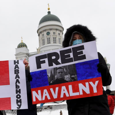Demonstration på Senatstorget i Helsingfors. Personer håller i plakat med texten "Free Navalnyj"
