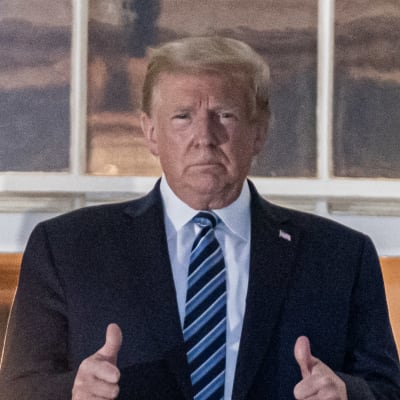 Donald Trump visar båda tummarna upp på Vita husets balkong.