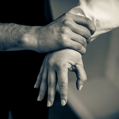 en manlig hand håller hårt on en kvinnas hand